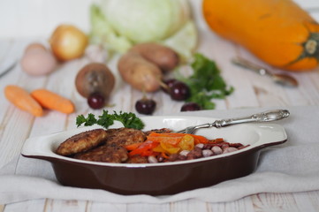 cutlets in a plate with ingredients on a white wooden table