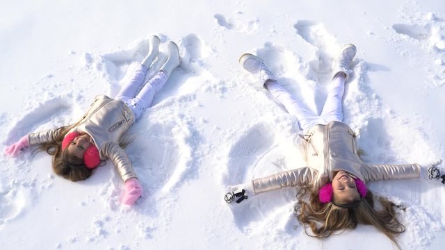 Children make winter angel. Theme Christmas holidays winter new year. Happy child with winter mood.
