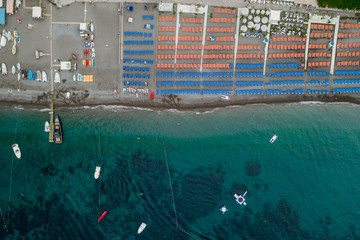 Obraz na płótnie Canvas Aerial overhead drone shot view of Positano beach with beach umbrella in morning time