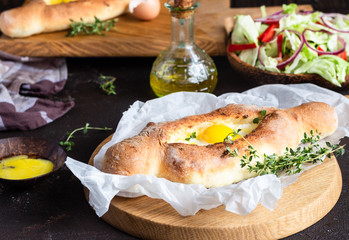 Khachapuri, traditional Georgian cuisine. Adjarian open bread pie with cheese and egg yolk. Caucasian kitchen. 