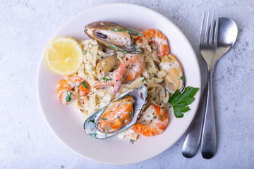 Seafood noodles. Homemade pasta with shrimp and mussels in a creamy sauce. Traditional italian dish. Close-up.