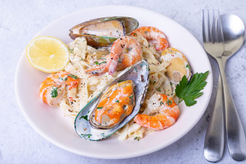 Seafood noodles. Homemade pasta with shrimp and mussels in a creamy sauce. Traditional italian dish. Close-up.