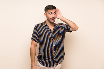 Handsome man with beard over isolated background listening something