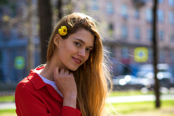Beautiful young blonde girl in red blouse. Street fashion look.