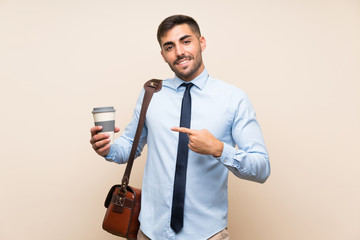 Young business with beard holding a take away coffee