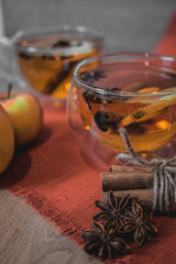 Apple Cider Drink, Juice, Punch, Tea with Spices, Cinnamon sticks, star anise and fresh Apples on a wooden background. Hot drink for Autumn and Winter evenings. Close up. Seasonal mulled drink.