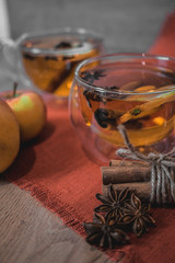 Apple Cider Drink, Juice, Punch, Tea with Spices, Cinnamon sticks, star anise and fresh Apples on a wooden background. Hot drink for Autumn and Winter evenings. Close up. Seasonal mulled drink.