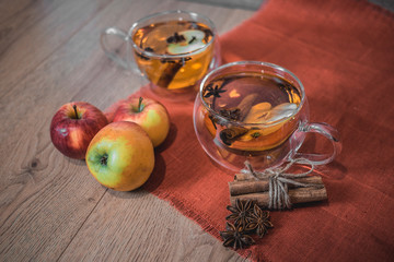 Apple Cider Drink, Juice, Punch, Tea with Spices, Cinnamon sticks, star anise and fresh Apples on a wooden background. Hot drink for Autumn and Winter evenings. Close up. Seasonal mulled drink.