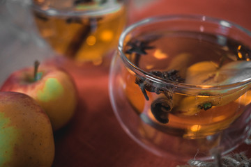 Apple Cider Drink, Juice, Punch, Tea with Spices, Cinnamon sticks, star anise and fresh Apples on a wooden background. Hot drink for Autumn and Winter evenings. Close up. Seasonal mulled drink.