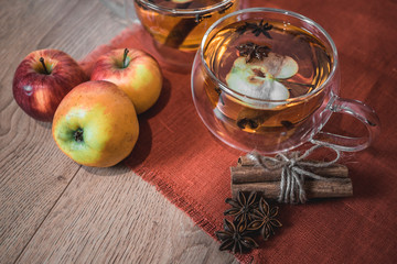 Apple Cider Drink, Juice, Punch, Tea with Spices, Cinnamon sticks, star anise and fresh Apples on a wooden background. Hot drink for Autumn and Winter evenings. Close up. Seasonal mulled drink.