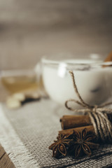 Glass cup of traditional indian masala chai tea. Indian masala chai tea - spiced tea with milk on rustic wooden background, selective focus, copy space. Close up.