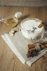 Glass cup of traditional indian masala chai tea. Indian masala chai tea - spiced tea with milk on rustic wooden background, selective focus, copy space. Close up.
