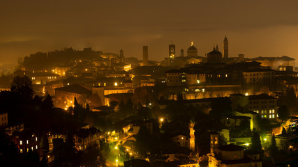 Bergamo, one of the most beautiful city in Italy. Amazing landscape of the fog rises from the plains and covers the old town during the evening. Fabulous context of Italian wonders