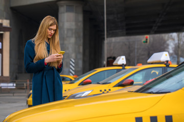 Young beautiful blonde woman calling by taxi
