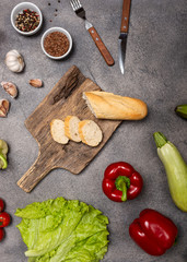 Healthy food clean eating selection of raw vegetables with a board on a dark background. Top view