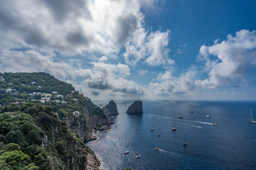 Crag cliff by Tyrrhenian sea in summer with dramatic couds, view from Garden of Augustus, Capri