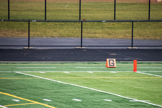 View of orange goal markers on American football field at high school staium