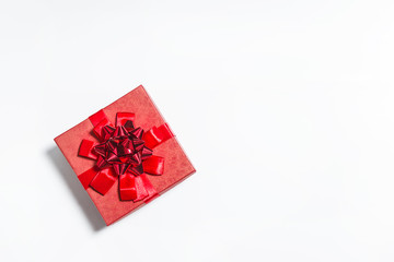 Beautiful red gift box with ribbon on the white background. Copy space, flat lay
