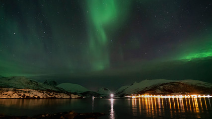 aurores boréales au bord d'un fjord tranquille gelé en norvège