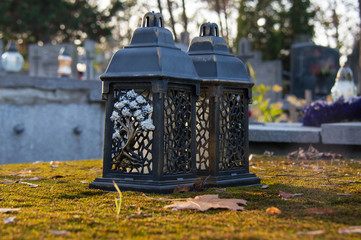 Monument and candles in the cemetery. All Saints Day in Poland. Moss on the tomb. Candles in the cemetery.