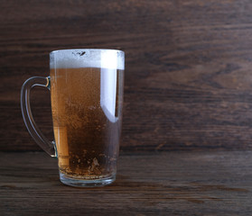 glass of beer against the background of oak panels