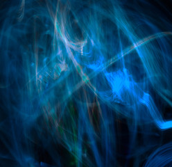 Long exposure, light painting photography, blue and multi color swirl and wave effect against a black background. Ghost effect.