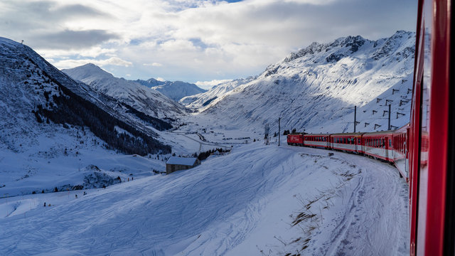 le Glacier express train rouge traverse un paysage alpin enneigé et ensoleillé en suisse