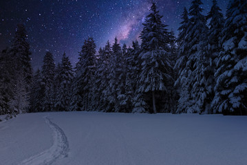 Magical Landscapes of the stars and the milky way with mountains and waterfalls with winter scenics for wallpaper backgrounds.