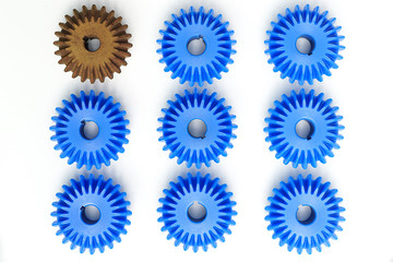 The brown Bevel Gears stand out from many blue crowds on a white background. Leadership, uniqueness, independence, initiative, strategy, dissent, think different, business success concept