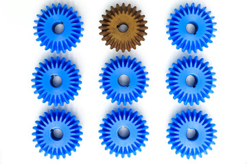 The brown Bevel Gears stand out from many blue crowds on a white background. Leadership, uniqueness, independence, initiative, strategy, dissent, think different, business success concept