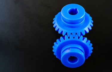 Blue Bevel Gears made of plastic on a black background.