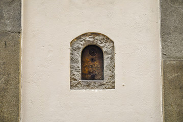 Close-up of a wine window (buchetta del vino), used in the past for the sale of wine directly on the street, on the wall of an ancient building in the historic centre of Florence, Tuscany, Italy
