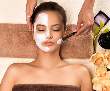 Woman having a facial cosmetic mask at spa salon.