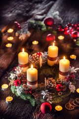 Advent wreath with four white burning candles christmas ball and decorations on a wooden background...