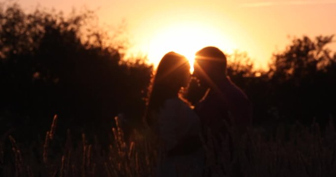Beautiful guy and girl hugging and kissing. Love story photo on outdoor in sunset light. Couple in love. Pretty girl and brutal bearded guy in outdoor.