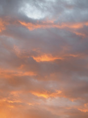Naklejka na ściany i meble Orange-gray clouds at sunset.
