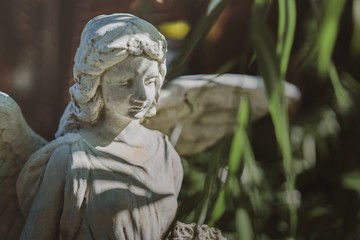 Antique sad angel statue in the garden