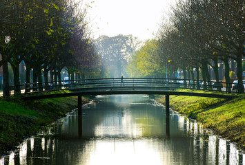 Person walking over a bridge in the neighborhood