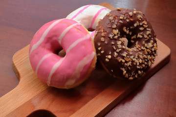 donuts of different flavors on a wooden cutting board