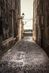 Narrow paved alley in old town Alghero