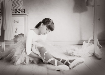 preteen girl in ballet class hall put on pointe