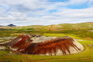 a small crater of a dormant volcano of Grábrók (Iceland)  green meadows in the tundra, arctic summer © Elena