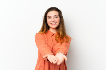 Young brunette girl over isolated white background holding copyspace imaginary on the palm to insert an ad