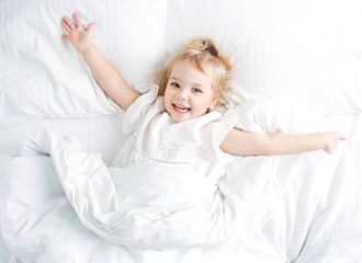 Cacasian baby child in a bed, happy morning healthy kid lifestyle.