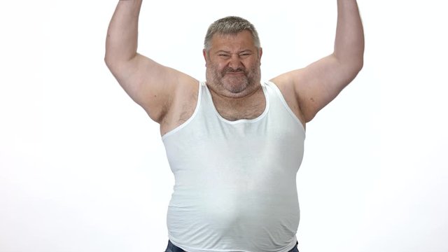 Obese man lifting heavy dumbbells, front view. Overweight guy on white background. Strength training for weight loss.
