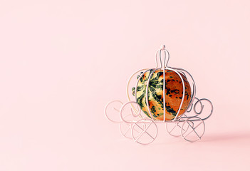 White miniature wire carriage and decorative pumpkin. The concept of love, holiday, magic or fairy tales. Selective focus, layout for design.