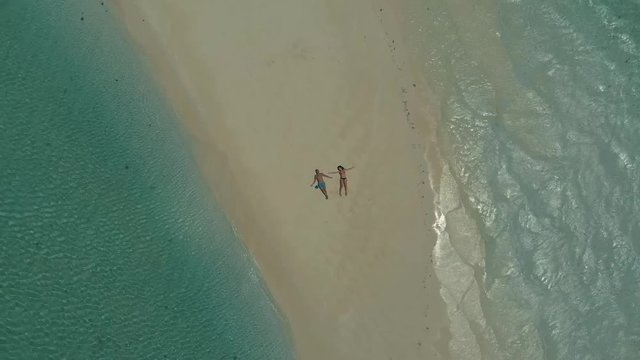 4K aerial top view of tropical sandbar. Aloha written made from starfishes on candaraman sandbar. drone turning around for romantic travel couple walking at sunset in Balabac, Palawan, Philippines