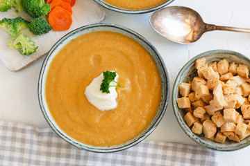 Cream vegetable soup broccoli, carrot, cauliflower with croutons. Vegetarian healthy food on light background