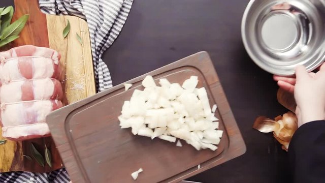 Flat lay. Dicing onion and garlic to season boneless pork roast.