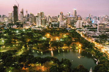Bangkok city skyline with Lumpini park and urban skyscrapers at twilight